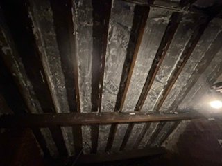Dark roof timbers in a loft, from a spray foam removal job